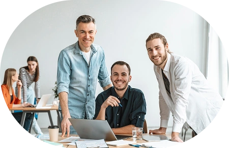 Sənədlər və noutbukla müasir ofis iş məkanında bir layihəni birlikdə müzakirə edən peşəkar komanda